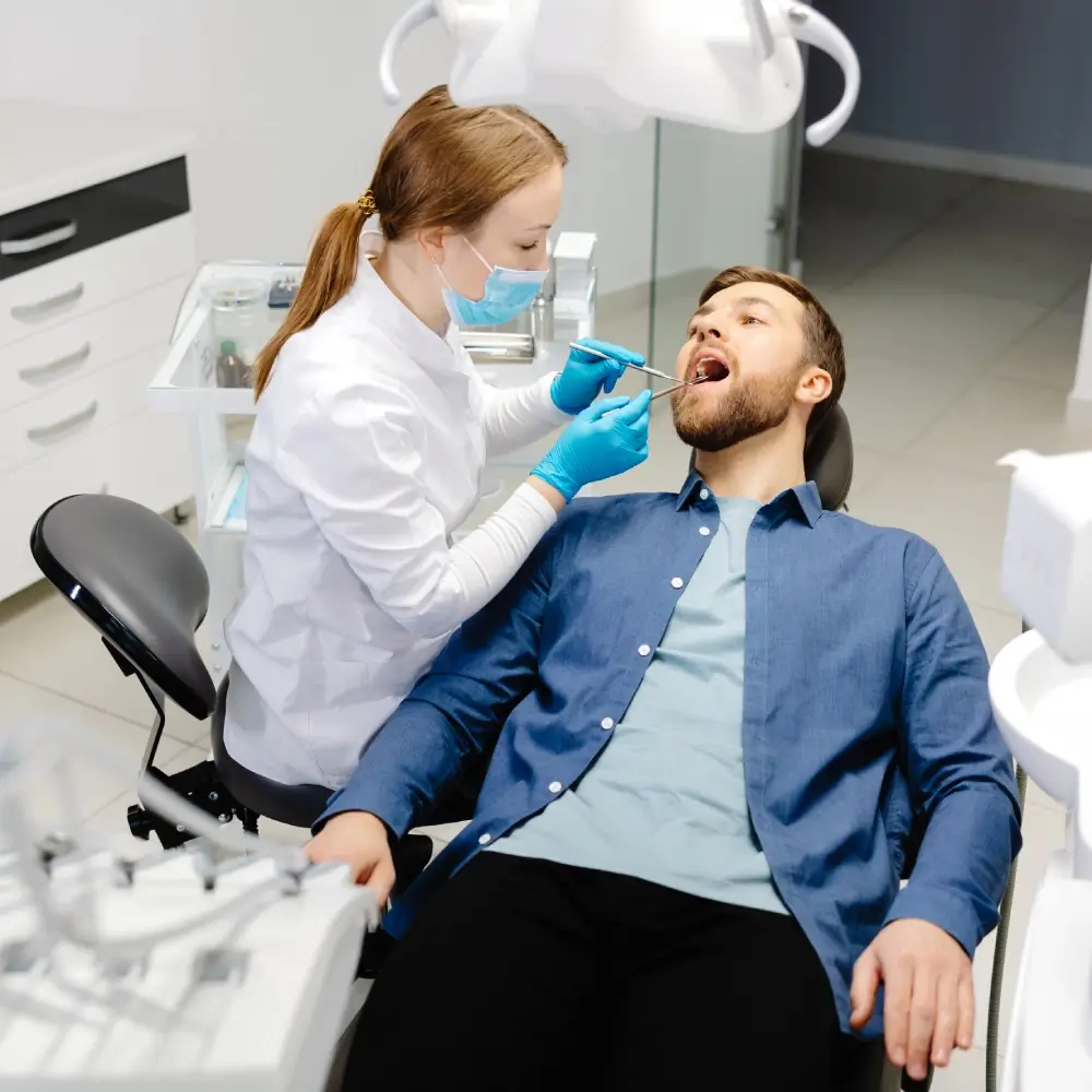 Dentist examining a patient's open mouth.