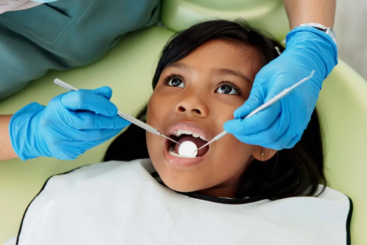 Child receiving dental examination from dentist.