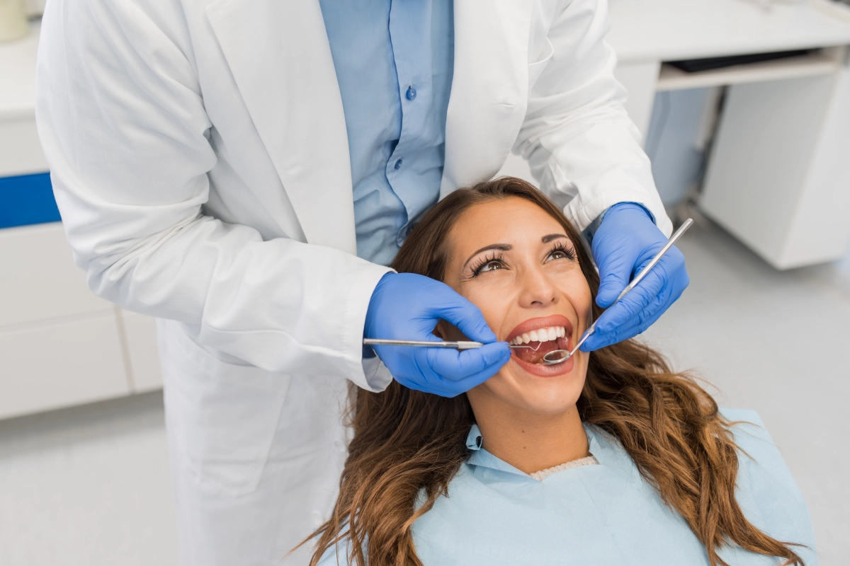Dentist examining a smiling patient's teeth.